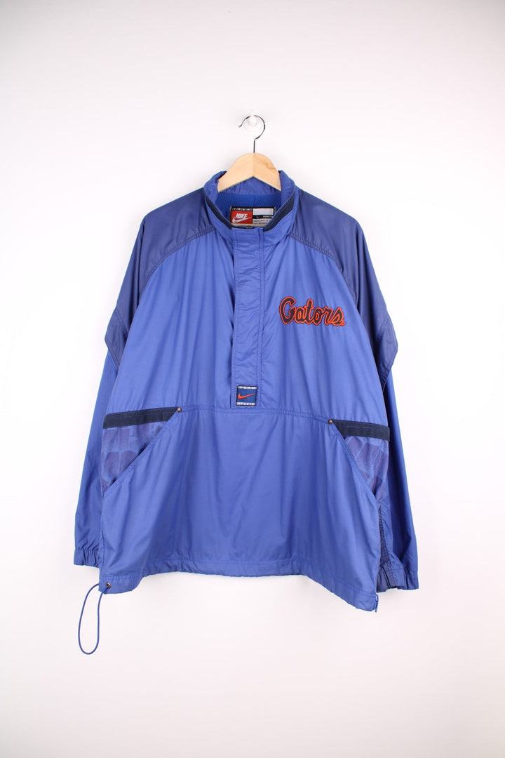 University of Florida Gators pro sport jacket in a blue colourway. Windbreaker with zip closure and team logos embroidered on the front and back.