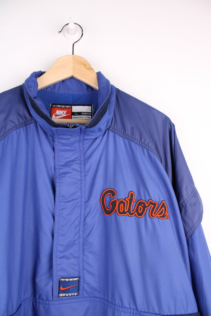 University of Florida Gators pro sport jacket in a blue colourway. Windbreaker with zip closure and team logos embroidered on the front and back.