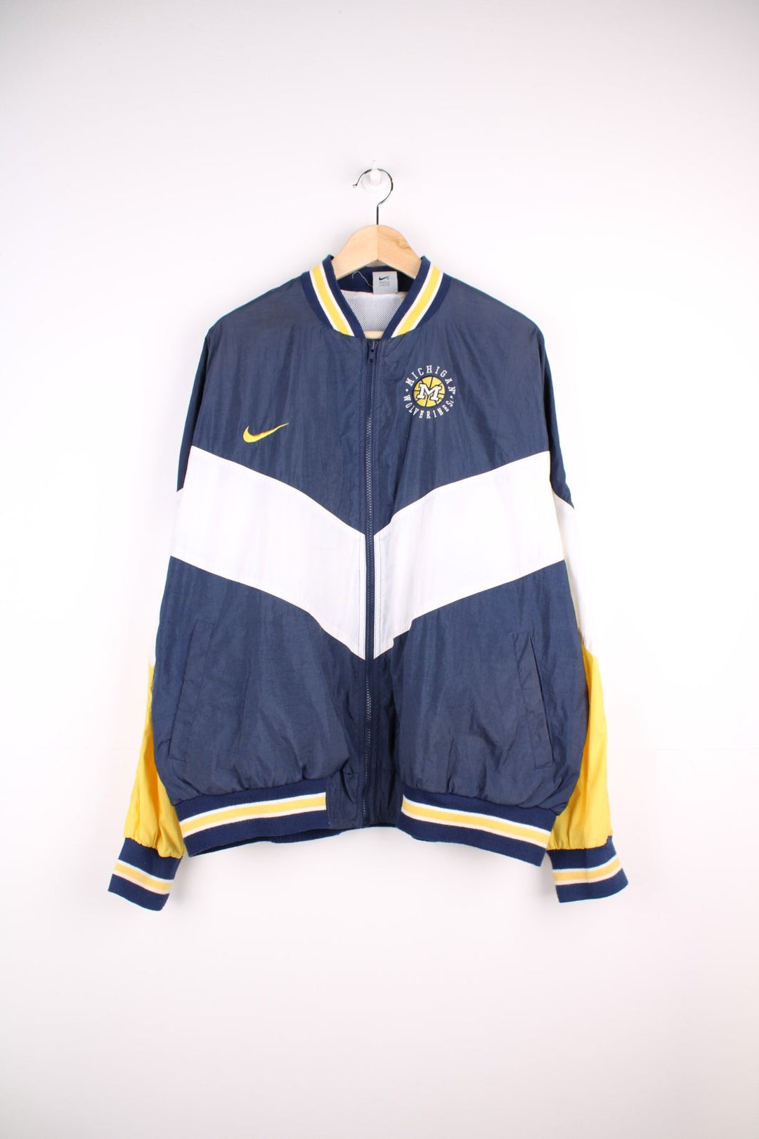 Michican Wolverines pro sport jacket in a navy colourway with white and yellow panels. Zip closure with team logos embroidered on the front and back.