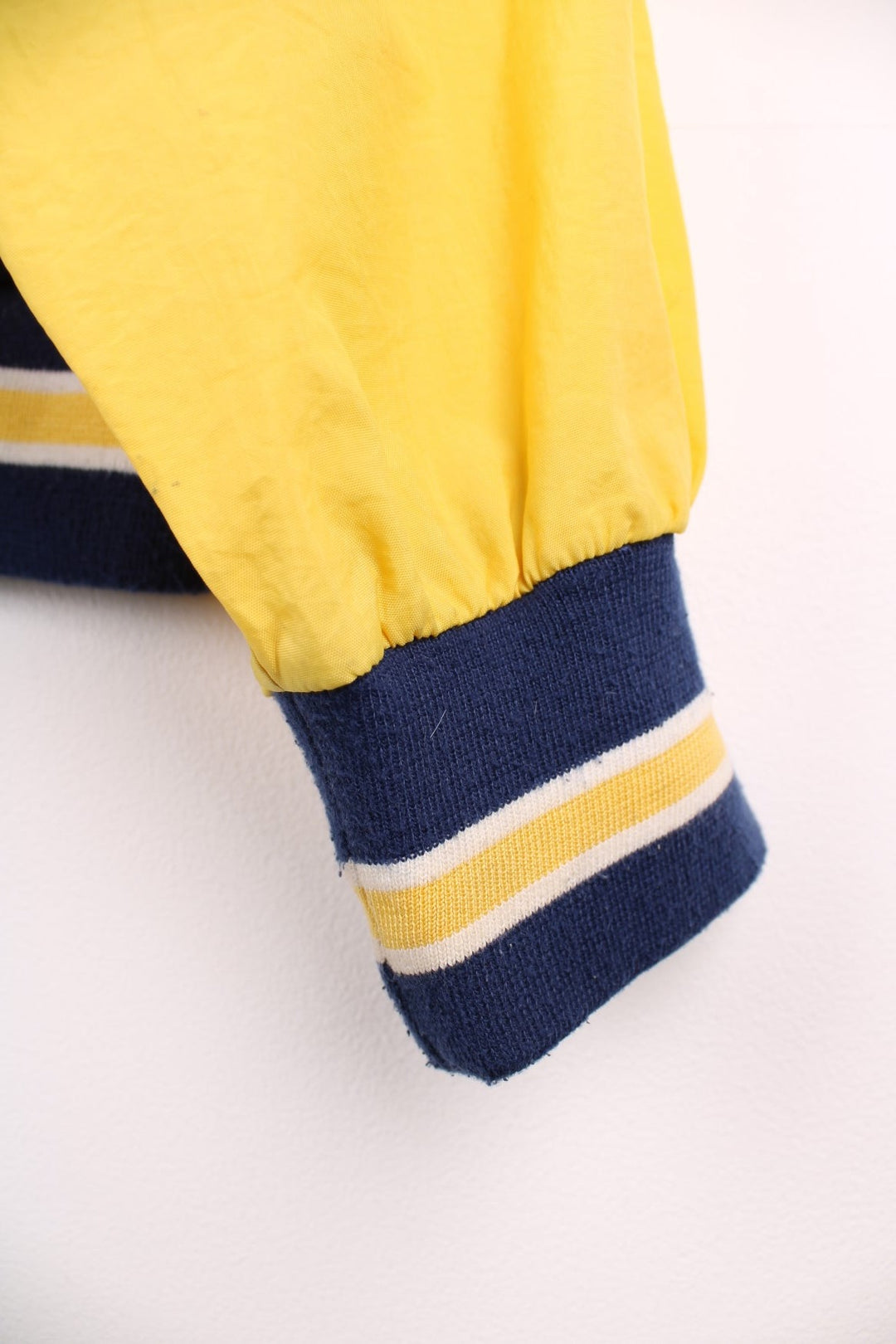 Michican Wolverines pro sport jacket in a navy colourway with white and yellow panels. Zip closure with team logos embroidered on the front and back.