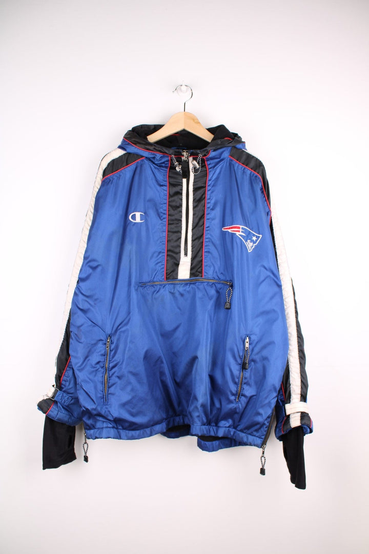 New England Patriots pro sport jacket in a blue colourway with white and red detail. Zip closure and hood with team logos embroidered on the front and back.