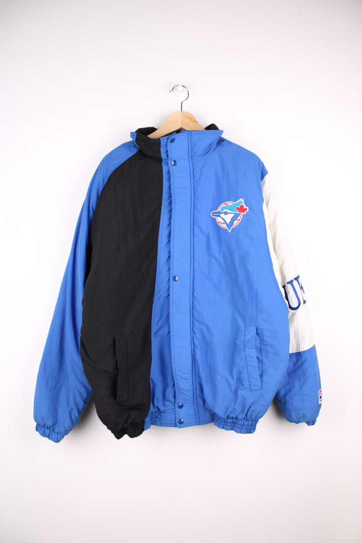 Toronto Blue Jays pro sport jacket in blue black and white. Zip and snap fastener closure with team logos embroidered on the front, back and sleeve.