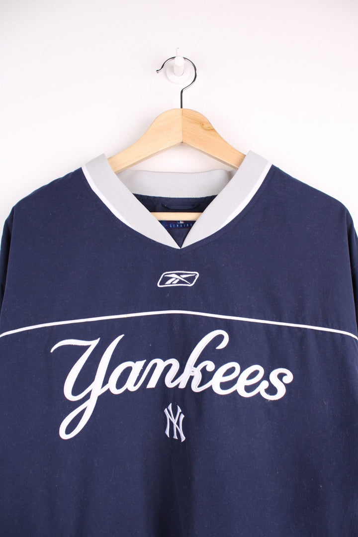 NY Yankees drill top in a navy colourway with Yankees and Reebok logos embroidered on the front.