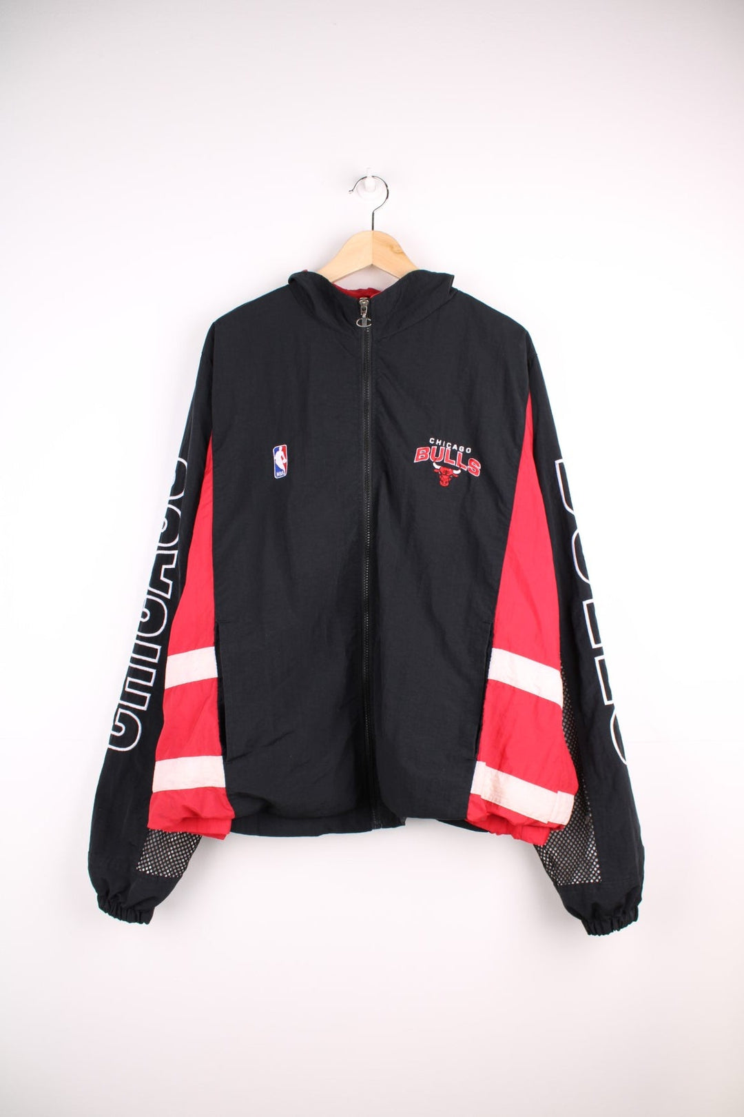 Chicago Bulls NBA pro sport jacket in a black colourway with red side panels. Full zip closure with team logos embroidered on the front and back.