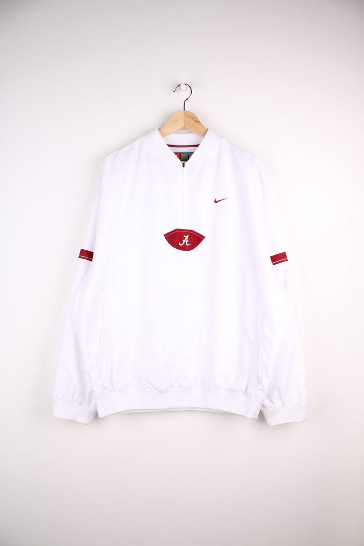 Alabama Crimson Tide Nike Windbreaker in a white colourway, quarter zip up and has a big pouch pocket, and the logos embroidered on the front.