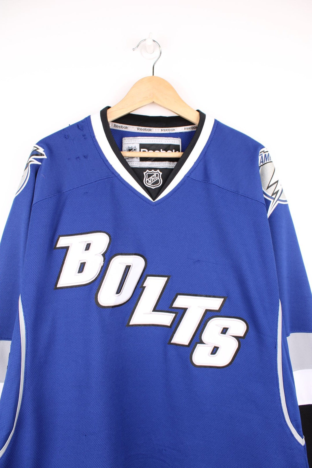 Tampa Bay Lightning Reebok, NHL Hockey Jersey. Features embroidered "BOLTS" across the front and badges on the sleeves. 