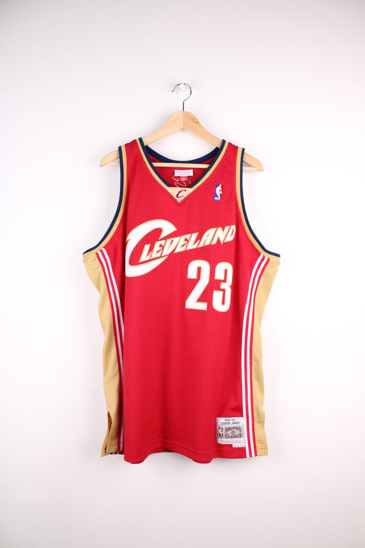 Cleveland Cavaliers NBA jersey in red with  yellow and navy accents, multiple embroidered logos, and no.23 James on the back.