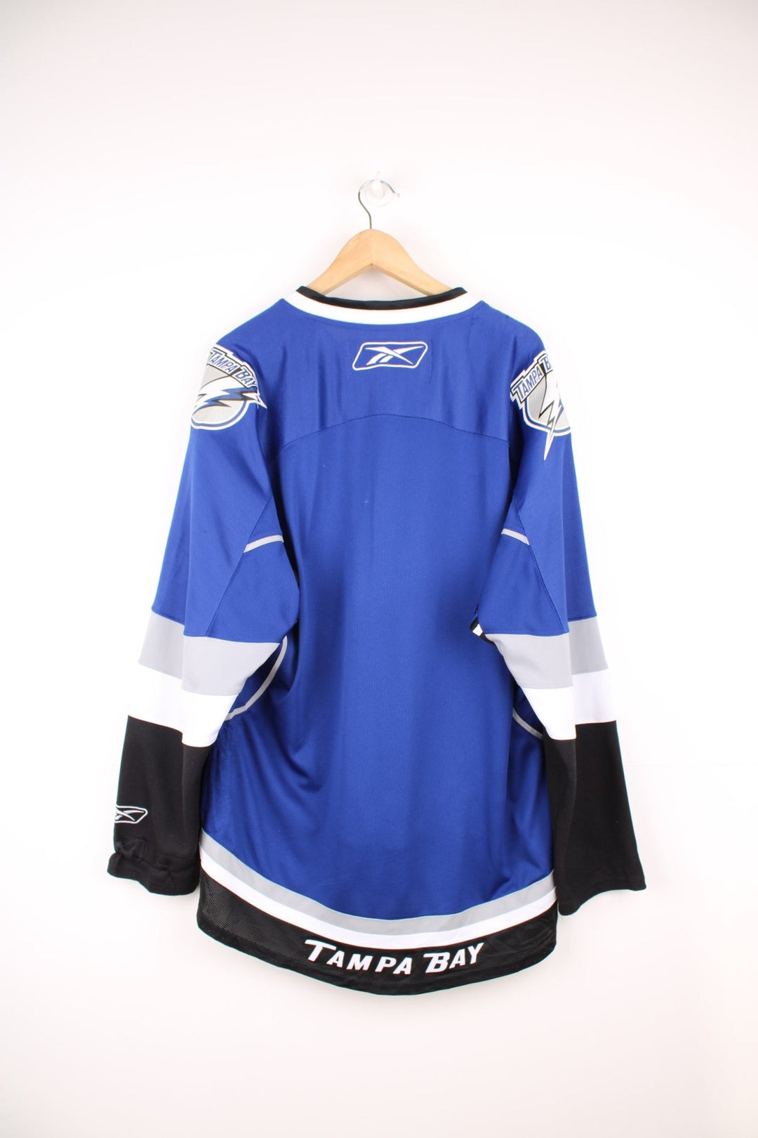 Tampa Bay Lightning Reebok, NHL Hockey Jersey. Features embroidered "BOLTS" across the front and badges on the sleeves. 