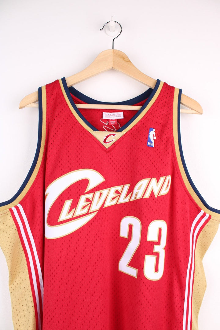 Cleveland Cavaliers NBA jersey in red with  yellow and navy accents, multiple embroidered logos, and no.23 James on the back.