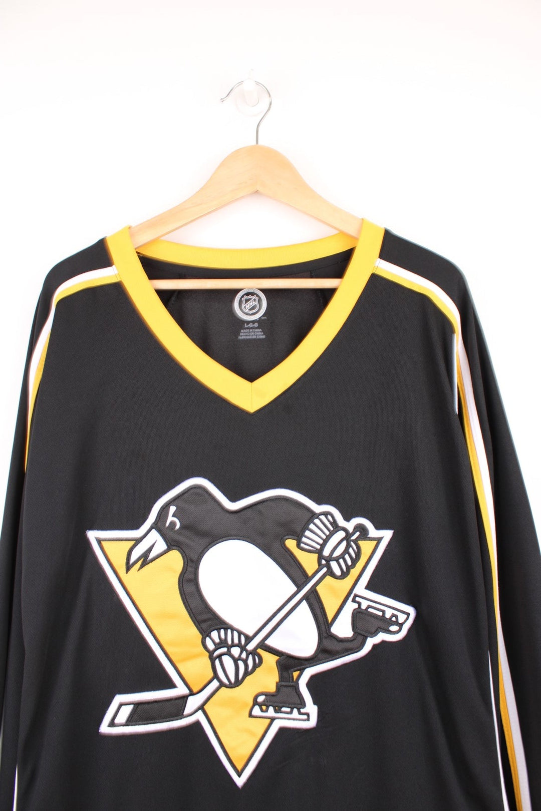 NHL Pittsburgh Penguins hockey jersey in a yellow and black colourway. Features large embroidered badge on the front.