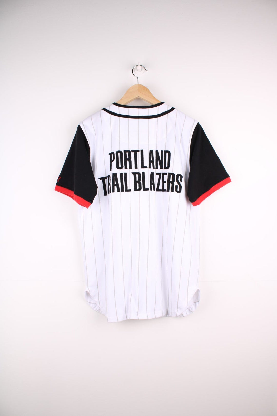 Portland Trail Blazers NBA button-up jersey in white with grey stripes and black and red accents, embroidered logos on the front and sleeve and team spellout on the back.