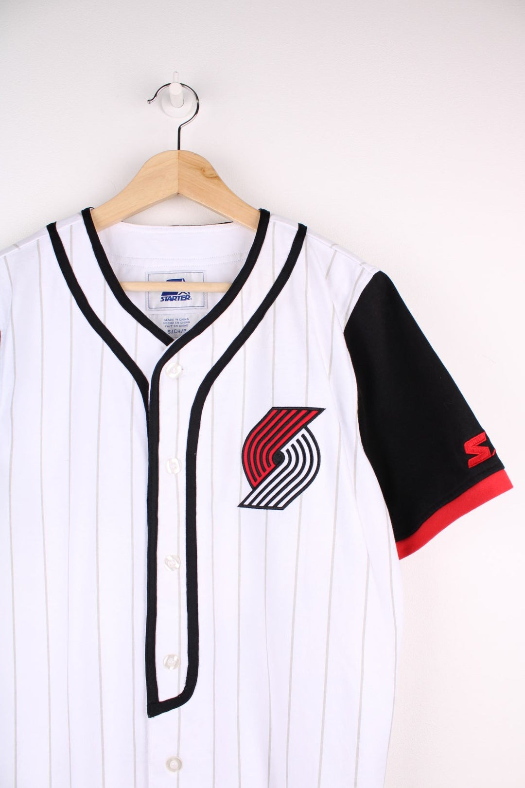 Portland Trail Blazers NBA button-up jersey in white with grey stripes and black and red accents, embroidered logos on the front and sleeve and team spellout on the back.