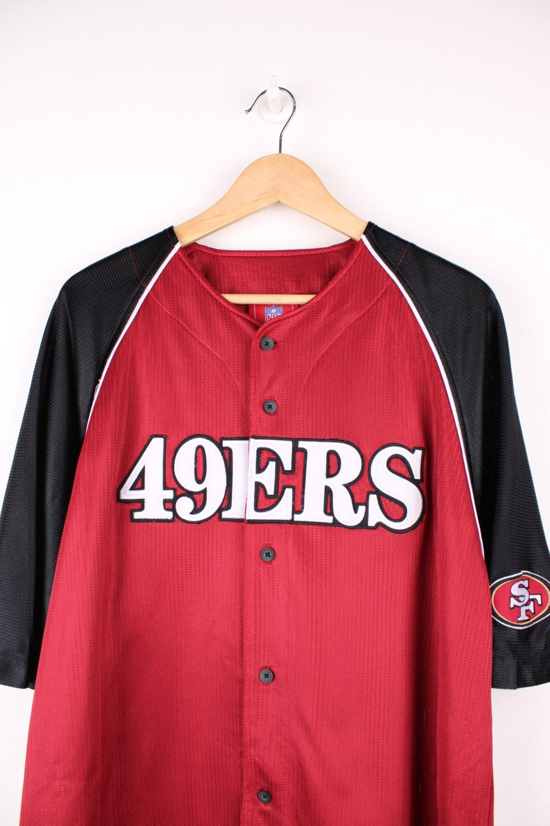 NFL San Francisco 49ers button up jersey in black and red with embroidered spell out logo across the front.