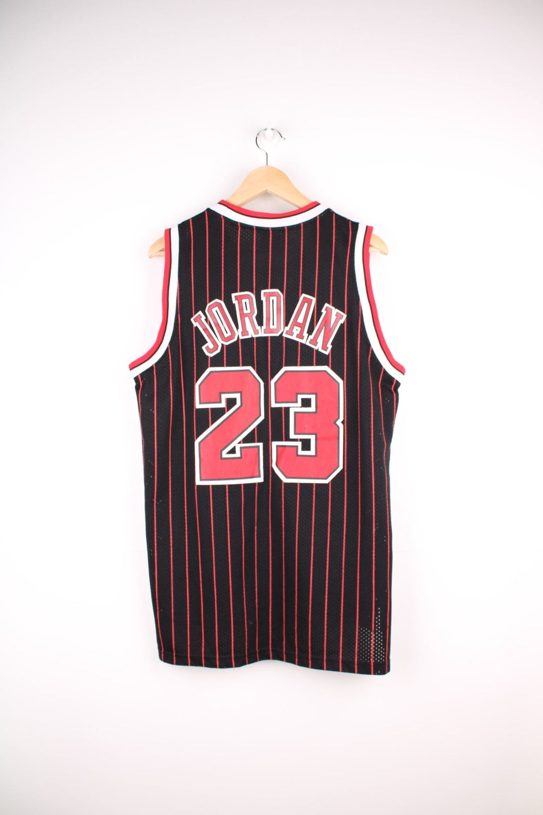 Chicago Bulls NBA jersey in black with red stripes, white accents, multiple embroidered logos, and no.23 Jordan on the front and back.