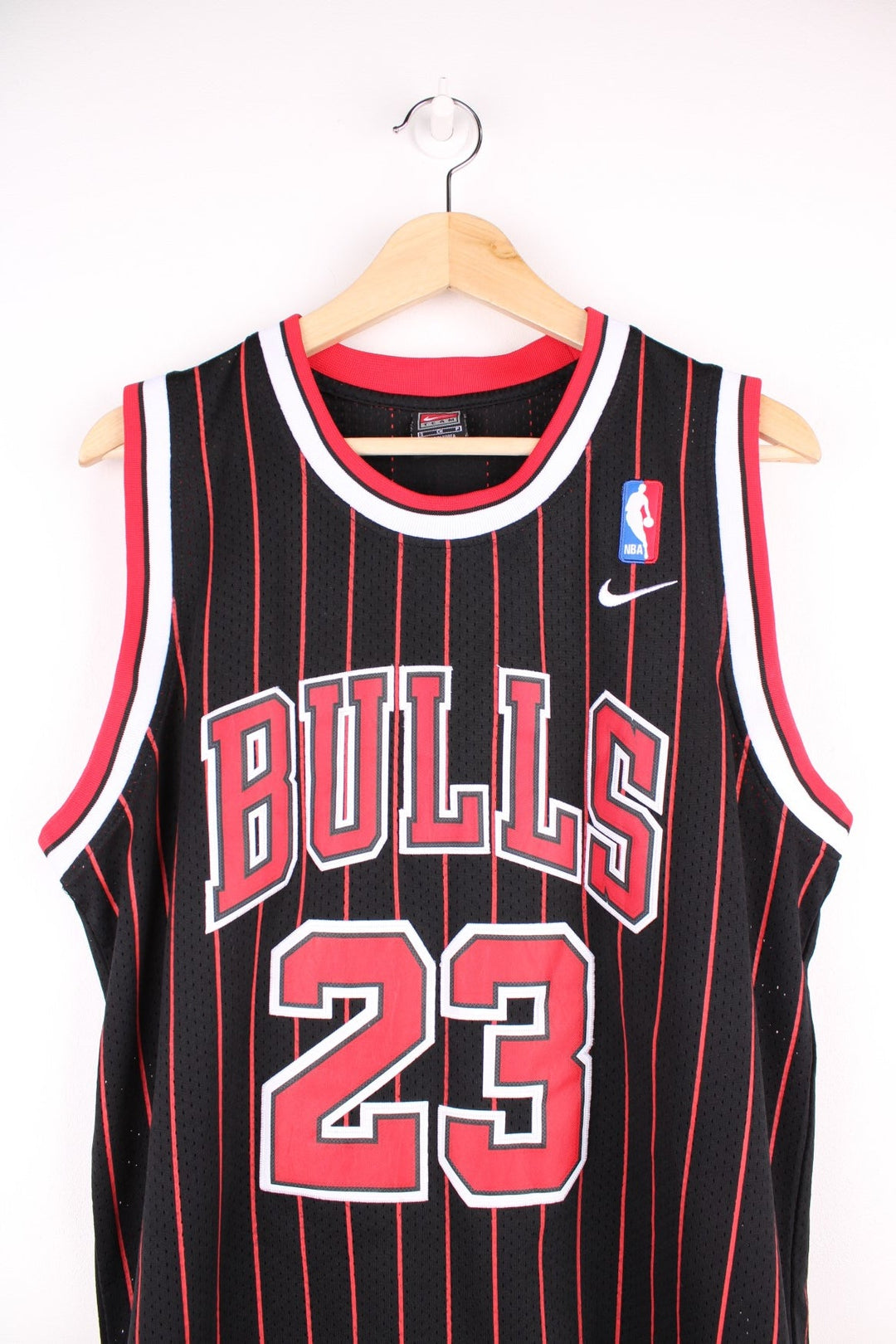 Chicago Bulls NBA jersey in black with red stripes, white accents, multiple embroidered logos, and no.23 Jordan on the front and back.