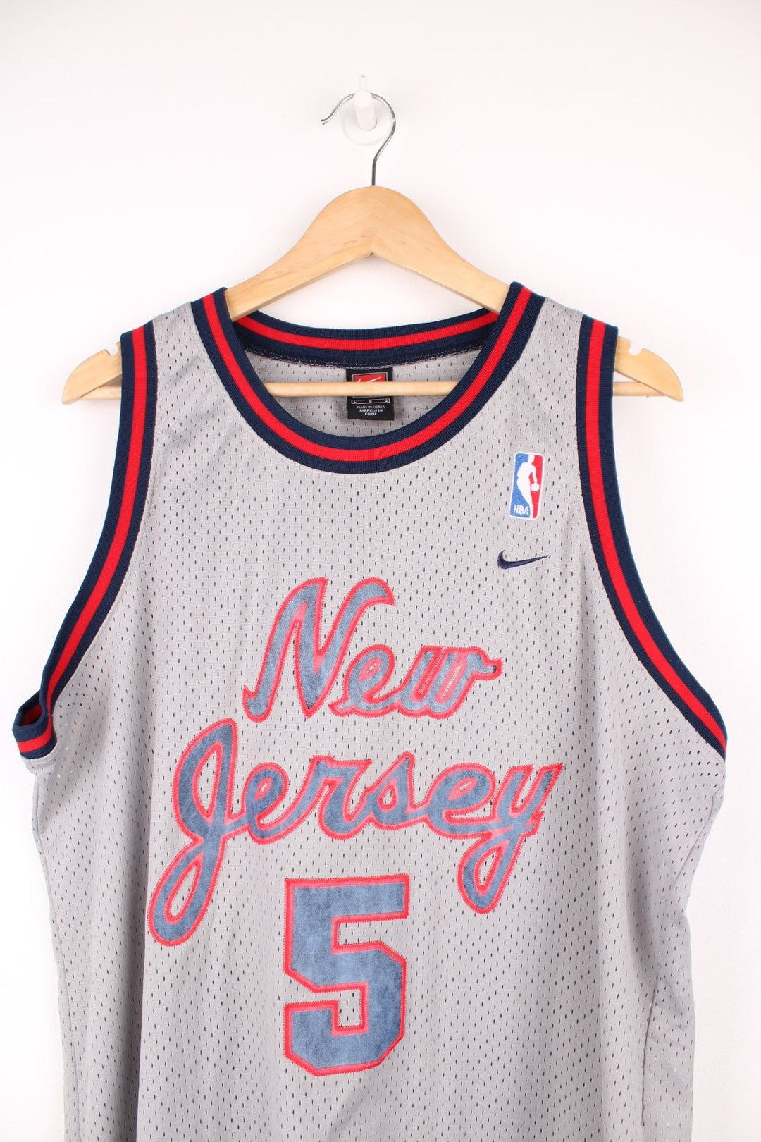 New Jersey Nets, Kidd #5 Nike NBA basketball jersey in a grey, red and blue colourway. Features embroidered lettering on the front and bag, and logos on the chest.