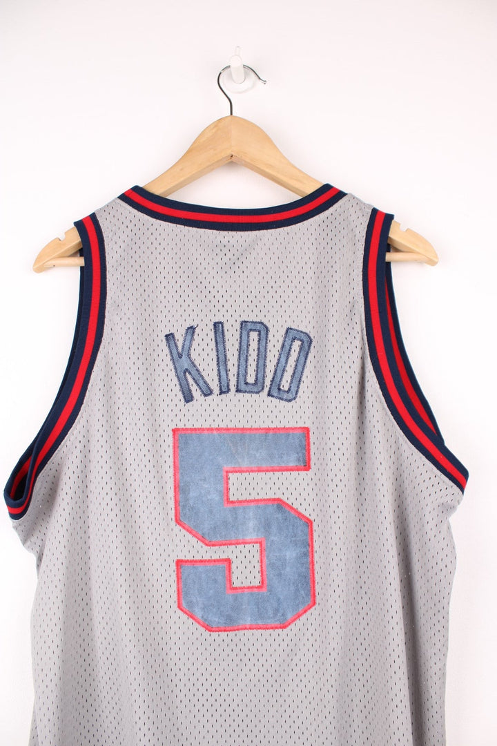 New Jersey Nets, Kidd #5 Nike NBA basketball jersey in a grey, red and blue colourway. Features embroidered lettering on the front and bag, and logos on the chest.