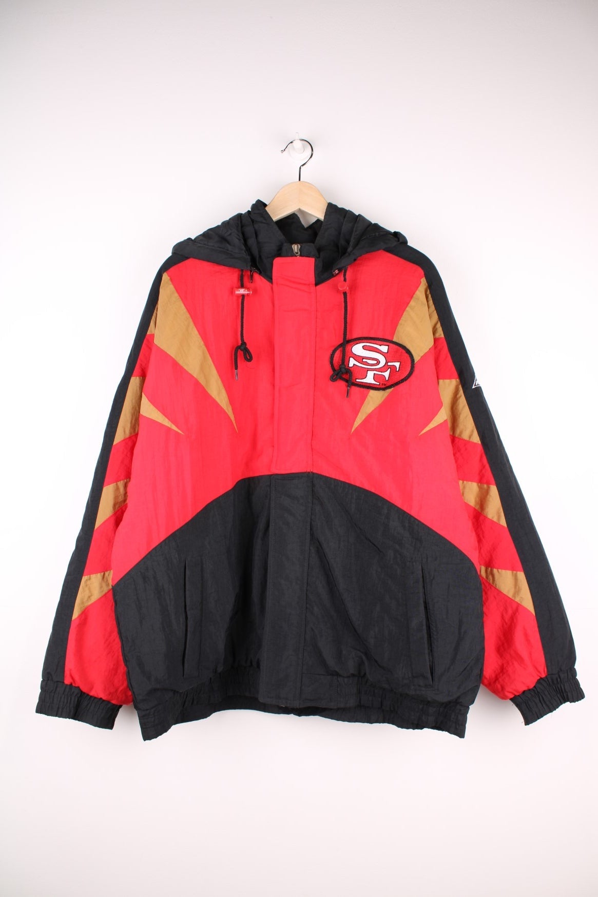 Vintage San Francisco 49ers Pro Line by Apex One Jacket in the red, black and gold team colourway, zip up with side pockets, has a detachable hood, quilted with a insulated lining, and has the logo embroidered on the front, sleeves, and back.