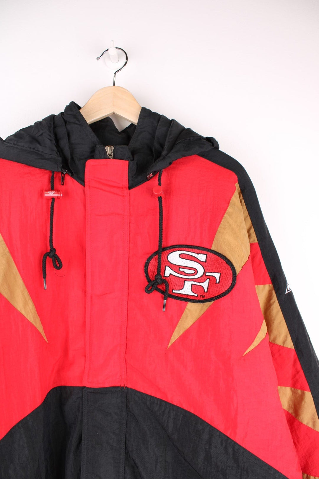 Vintage San Francisco 49ers Pro Line by Apex One Jacket in the red, black and gold team colourway, zip up with side pockets, has a detachable hood, quilted with a insulated lining, and has the logo embroidered on the front, sleeves, and back.