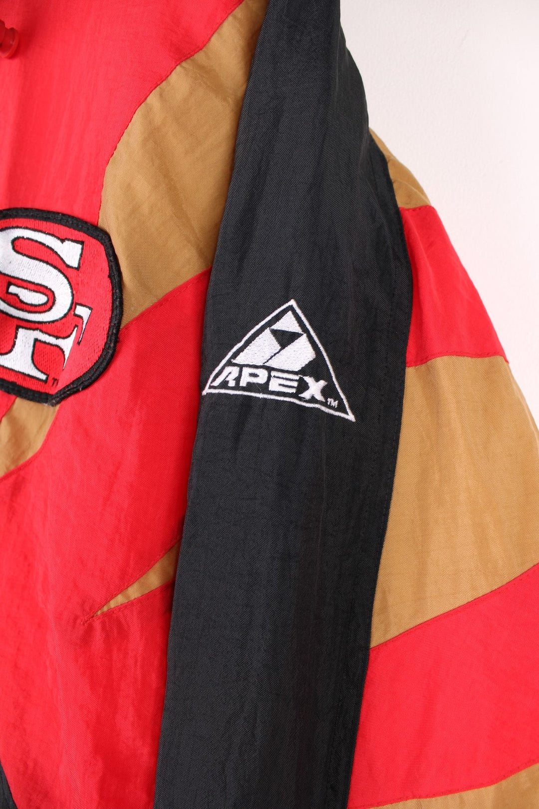 Vintage San Francisco 49ers Pro Line by Apex One Jacket in the red, black and gold team colourway, zip up with side pockets, has a detachable hood, quilted with a insulated lining, and has the logo embroidered on the front, sleeves, and back.