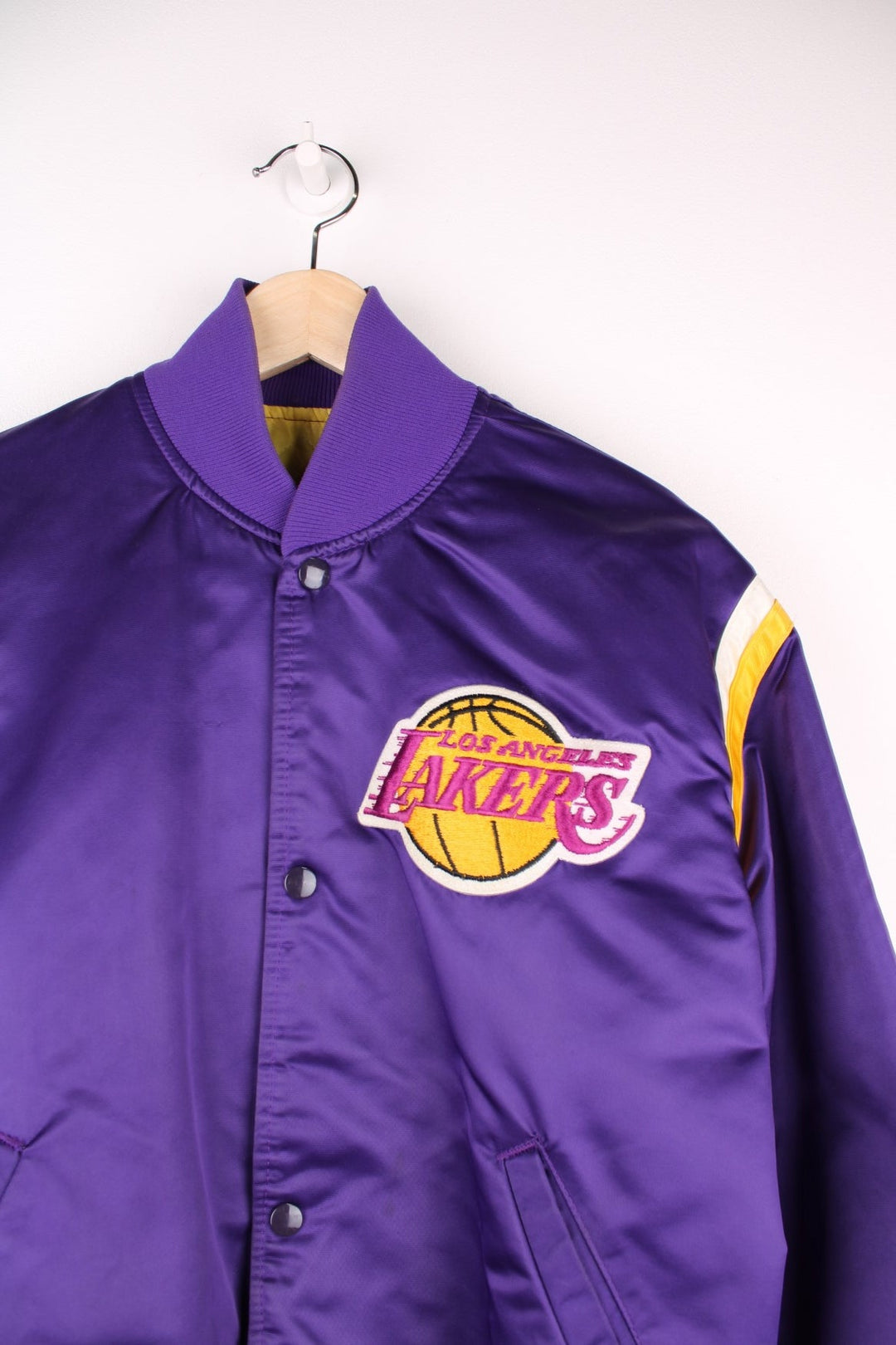 Los Angeles Lakers Starter NBA Varsity Jacket in a purple, yellow and white colourway, button up with side pockets, insulated with a quilted lining, and has the team and NBA logo embroidered on the front.