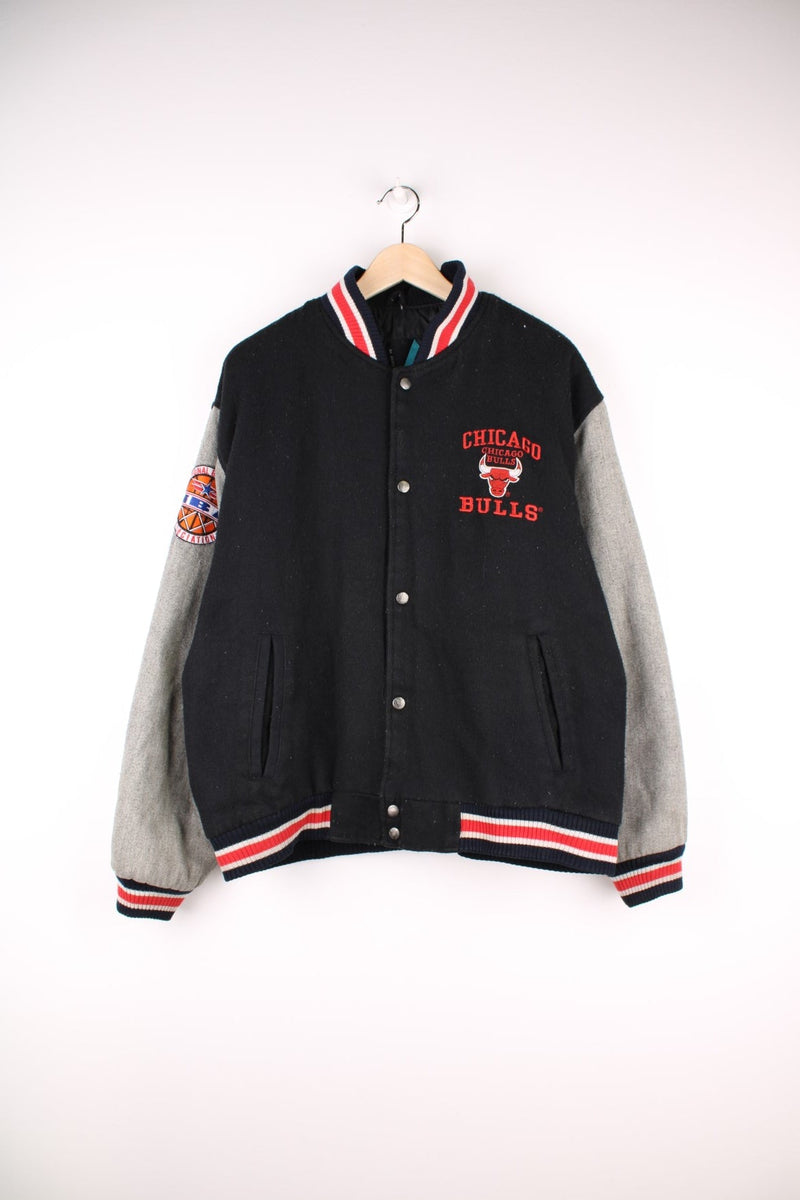 Vintage 90's Chicago Bulls Logo 7 Woolen Varsity Jacket Athletic in a black, grey and red colourway, button up with side pockets, insulated with a quilted lining, and has the team spell out and logo embroidered on the front and back.