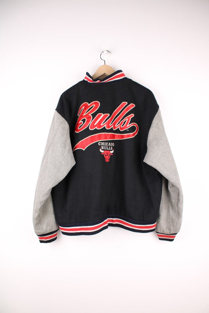 Vintage 90's Chicago Bulls Logo 7 Woolen Varsity Jacket Athletic in a black, grey and red colourway, button up with side pockets, insulated with a quilted lining, and has the team spell out and logo embroidered on the front and back.