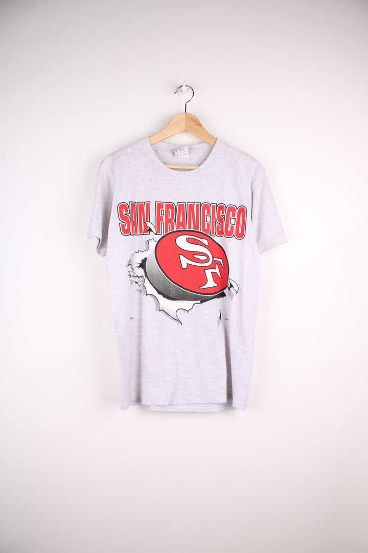 San Francisco 49ers NFL t-shirt in grey with front and back graphic of team logo bursting through the t-shirt.