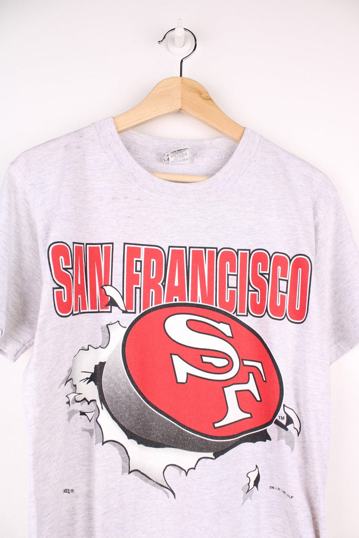 San Francisco 49ers NFL t-shirt in grey with front and back graphic of team logo bursting through the t-shirt.