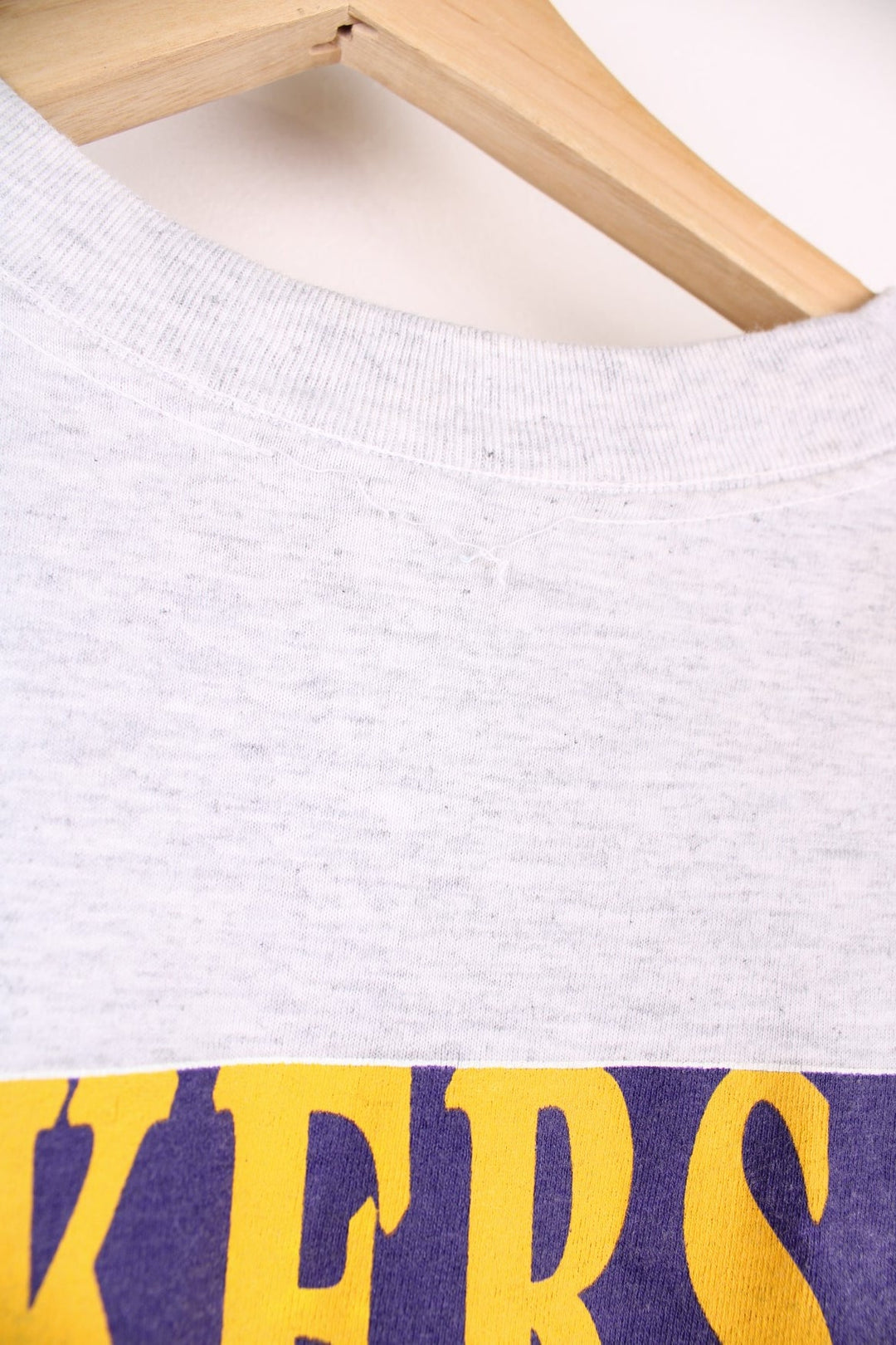 Los Angeles Lakers NBA Magic Johnson t-shirt in grey with yellow and purple accents, multiple team/NFL logos, illustrations of Johnson and his stats and a bio written on the back.