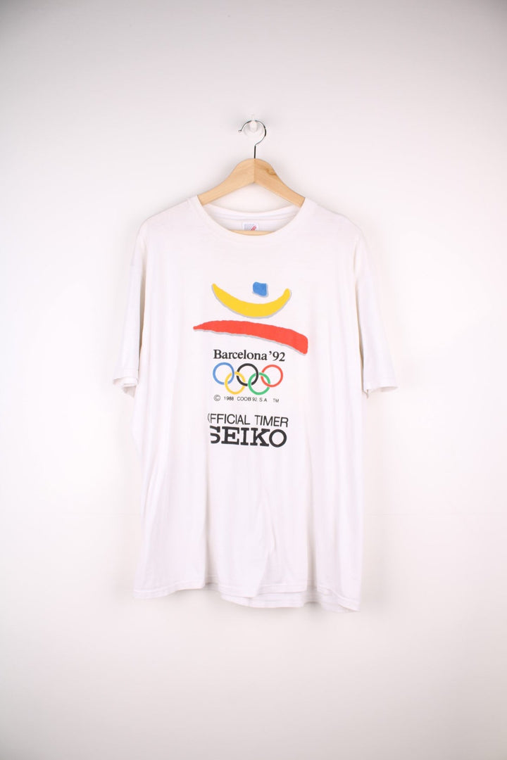 Vintage 1992 Barcelona Olympics tee in white with red, yellow and blue abstract designs and Seiko sponsorship spellout.