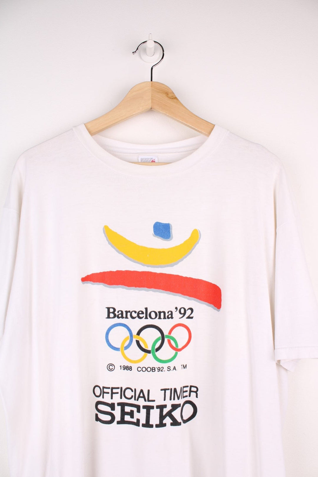 Vintage 1992 Barcelona Olympics tee in white with red, yellow and blue abstract designs and Seiko sponsorship spellout.