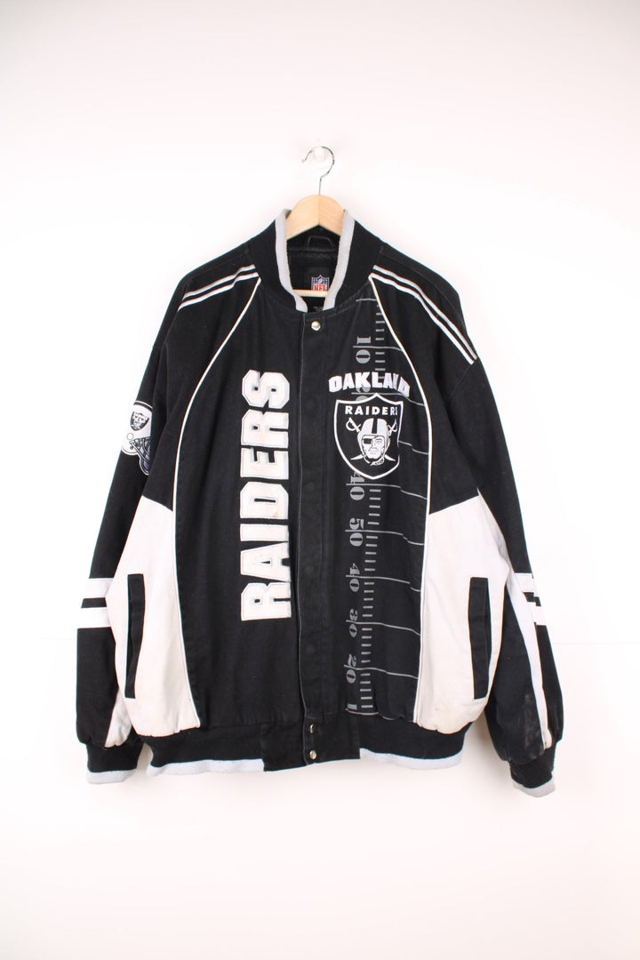 NFL Oakland Raiders jacket in black and white. Features embroidered badge on the front and back.