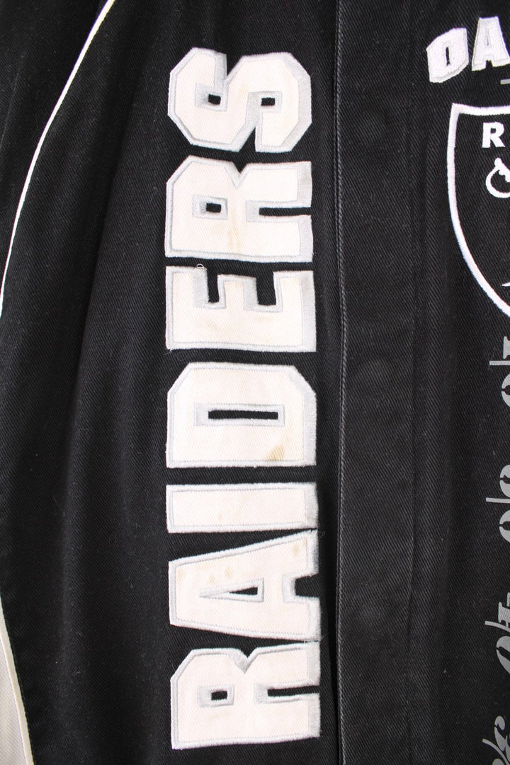 NFL Oakland Raiders jacket in black and white. Features embroidered badge on the front and back.