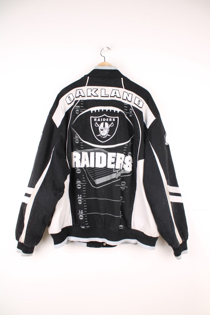 NFL Oakland Raiders jacket in black and white. Features embroidered badge on the front and back.