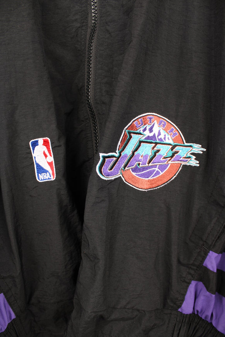 Vintage 1996 Utah Jazz NBA zip through track jacket in black and purple by Starter, features embroidered logos and badges