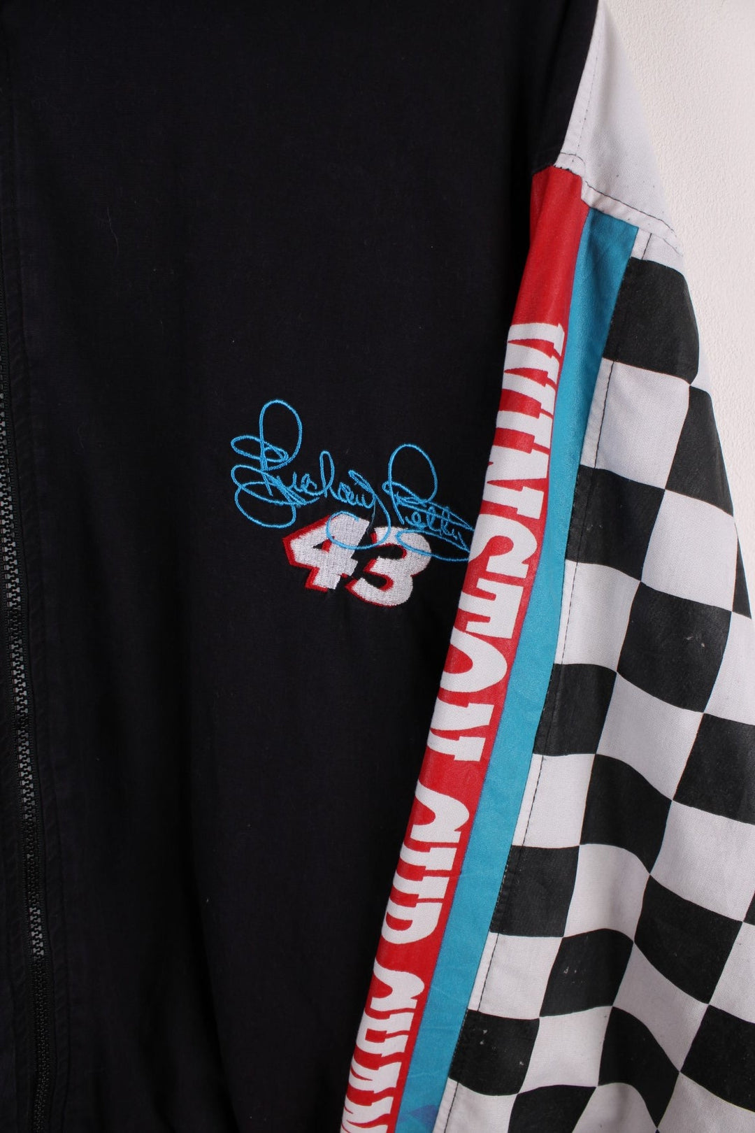 Vintage Richard Petty  Racing Windbreaker in a  colourway with racing flag print going down the sleeve, alongside his name spell out down the sleeves, and his car and racing number 43 on the back.