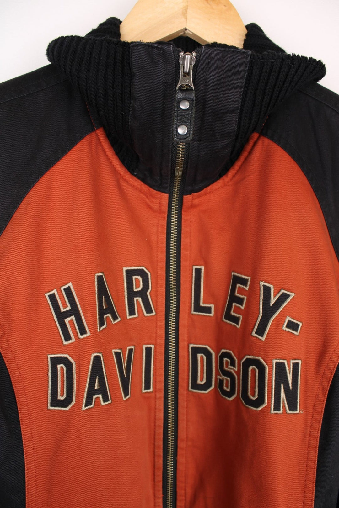  Jacket in a  and orange colourway, zips up and has a big collar, side pockets, and the spell out logo embroidered across the front.