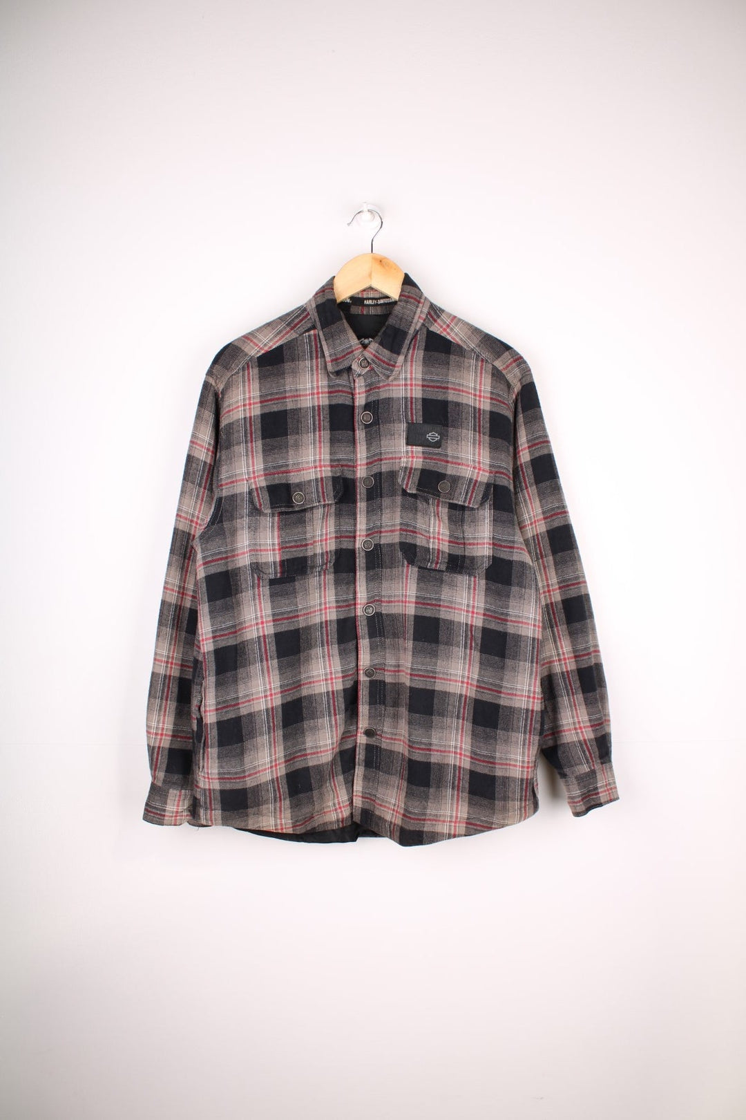 Harley-Davidson Flannel Style Shacket in a grey, black and red plaid colourway, buttons up, has multiple pockets, quilted lining and the logo embroidered on the front and back.