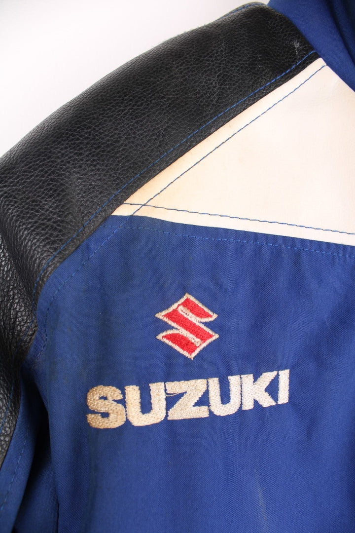 Vintage Suzuki racing jacket in blue, black and white. Features embroidered logo. 