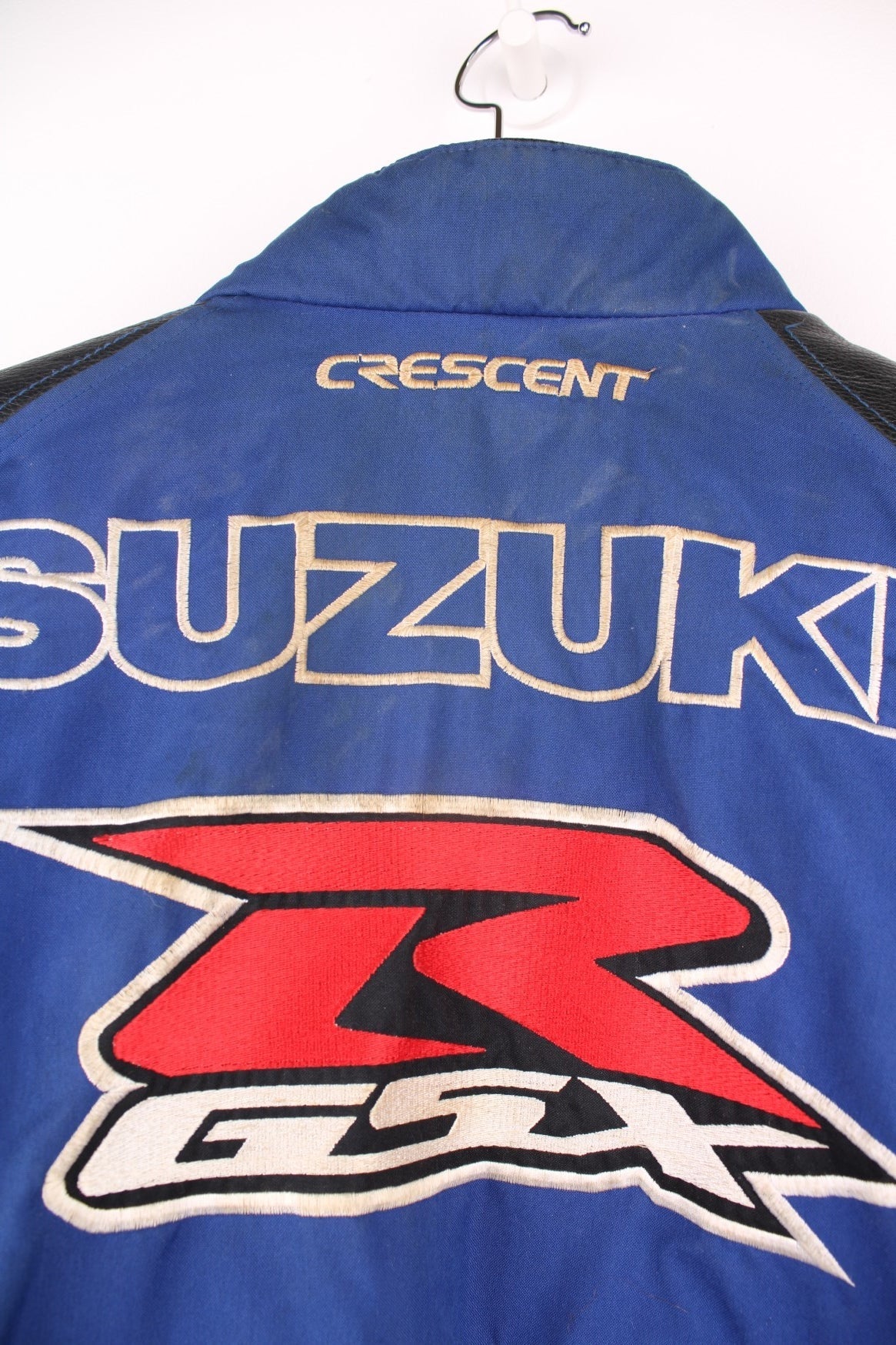 Vintage Suzuki racing jacket in blue, black and white. Features embroidered logo. 