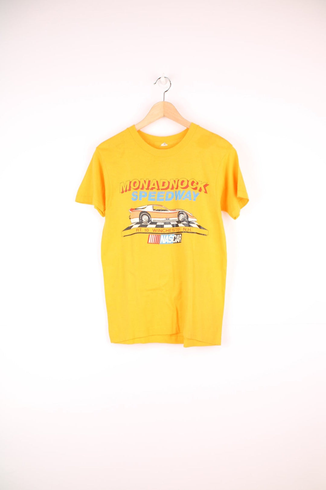 Vintage 80's Nascar Single Stitch T-Shirt in a yellow colourway, Monadnock Speedway race course, has the spell out and nascar printed on the front.