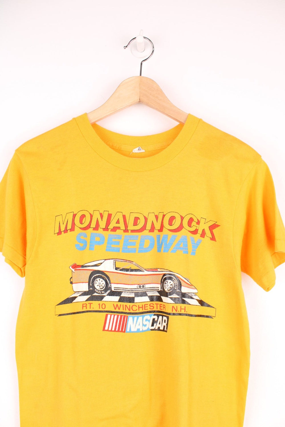 Vintage 80's Nascar Single Stitch T-Shirt in a yellow colourway, Monadnock Speedway race course, has the spell out and nascar printed on the front.