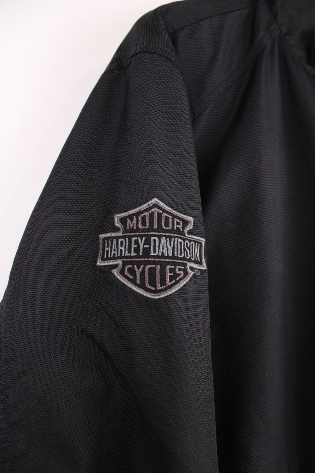 Harley Davidson reversible motorcycle jacket in black and grey colourway. Features embroidered spell-out details across the shoulders and on the front