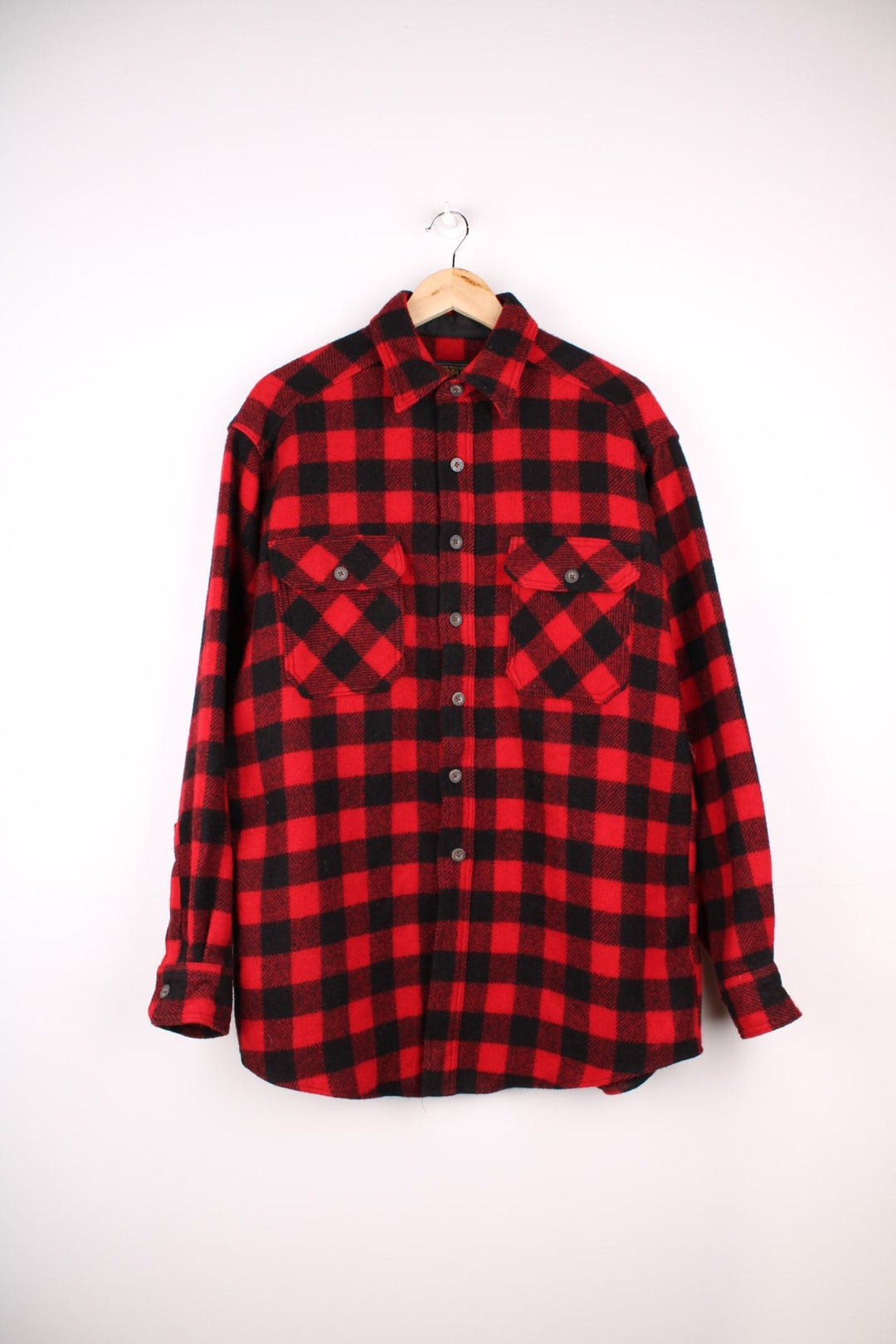 Woolrich overshirt in red and black check with button closure and two buttoned pockets.