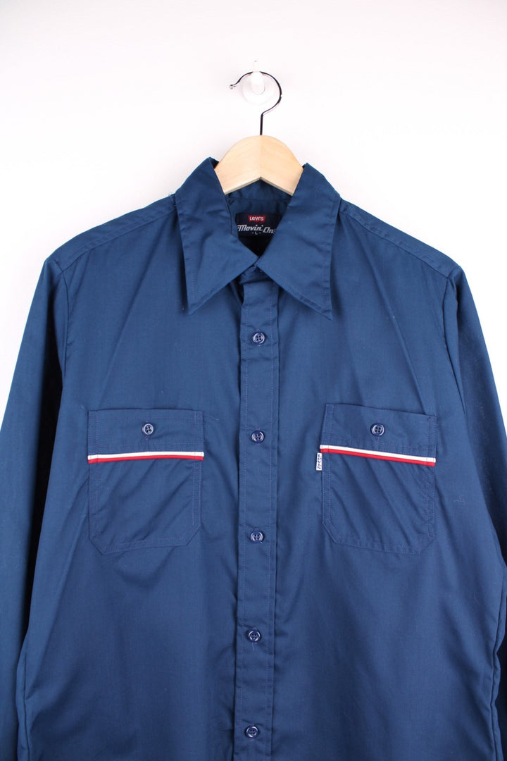 Levi's shirt in Blue with a dagger collar, red and white stripe detailing, two pockets and button closure.