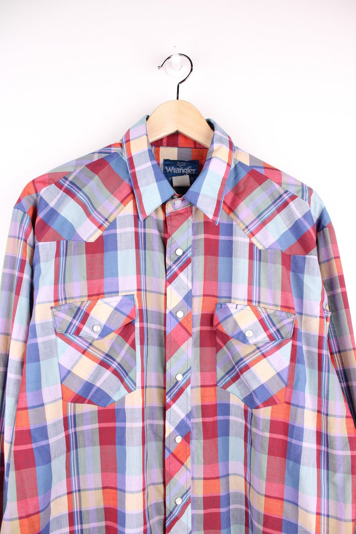 Wrangler western shirt in blue, red, yellow, and green check with two pockets and pearl-effect snap closure.