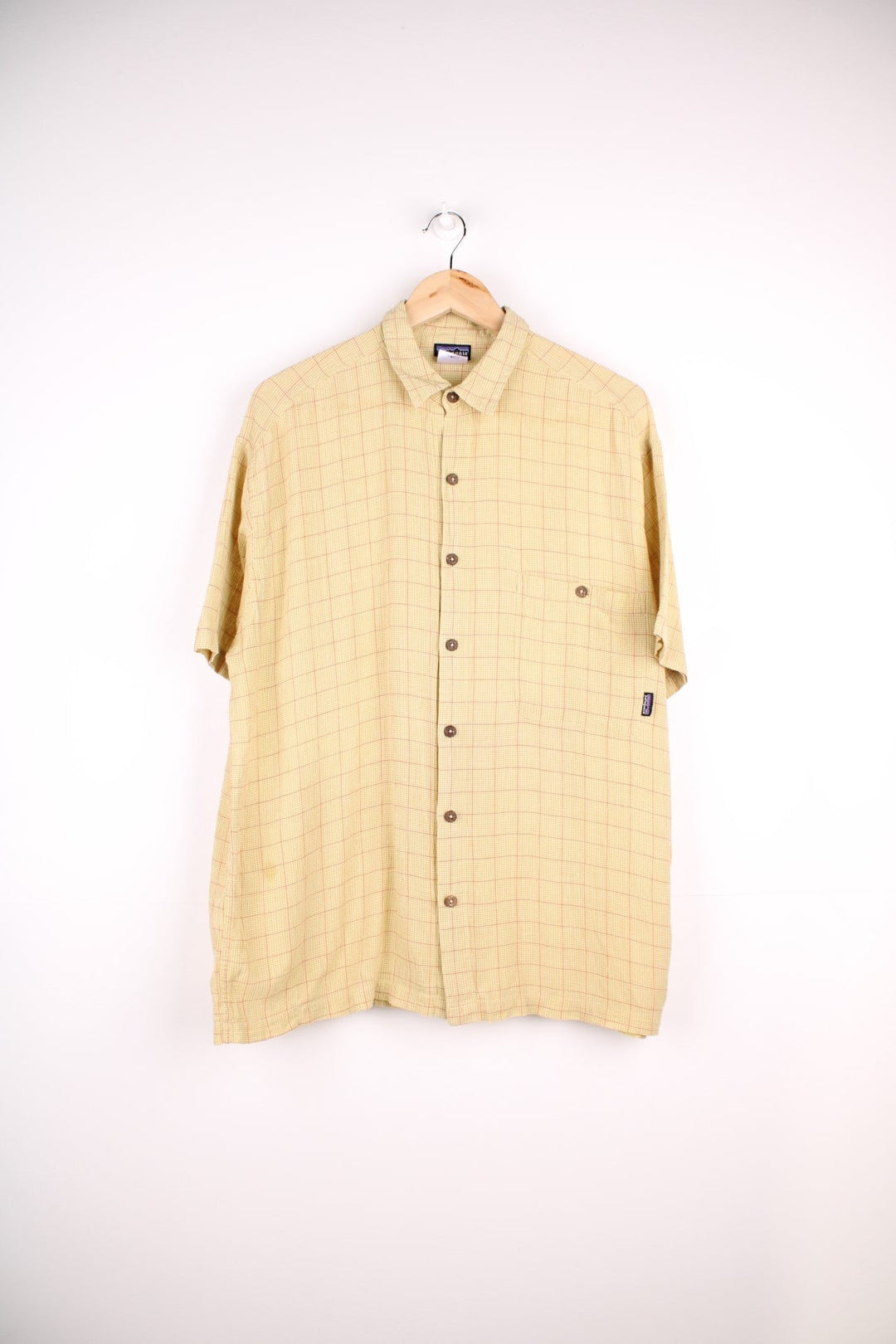 Patagonia organic cotton shirt in light green and orange check with button closure, one chest pocket and a small logo tab.