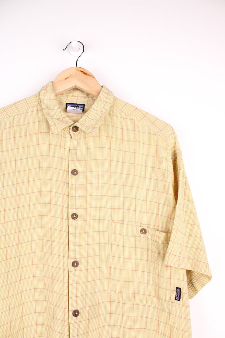 Patagonia organic cotton shirt in light green and orange check with button closure, one chest pocket and a small logo tab.