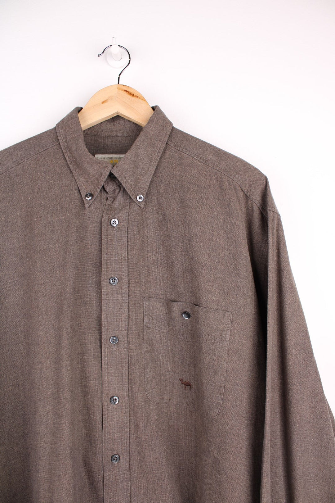 Camel button-down shirt in brown with button closure, one chest pocket, and a small embroidered camel logo. .